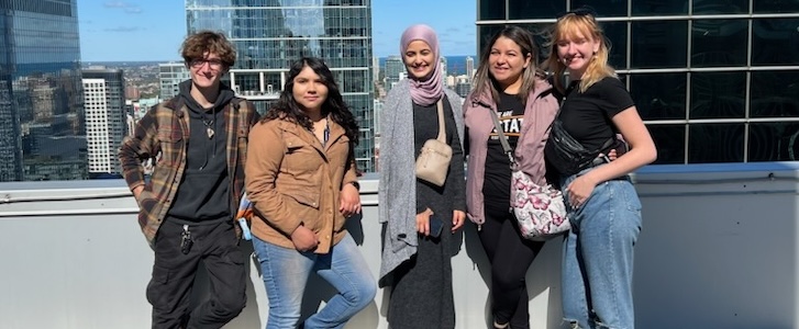 Honors students standing and smiling on rooftop